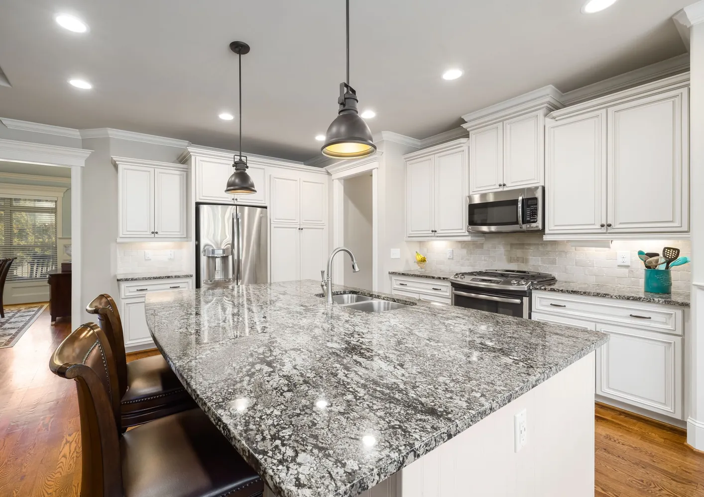 Cocina blanca con isla de granito gris y blanco