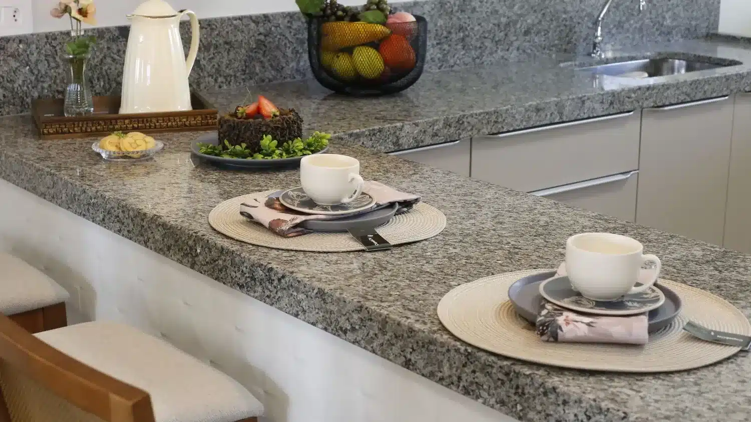 Encimera de granito gris en una cocina con barra de desayuno